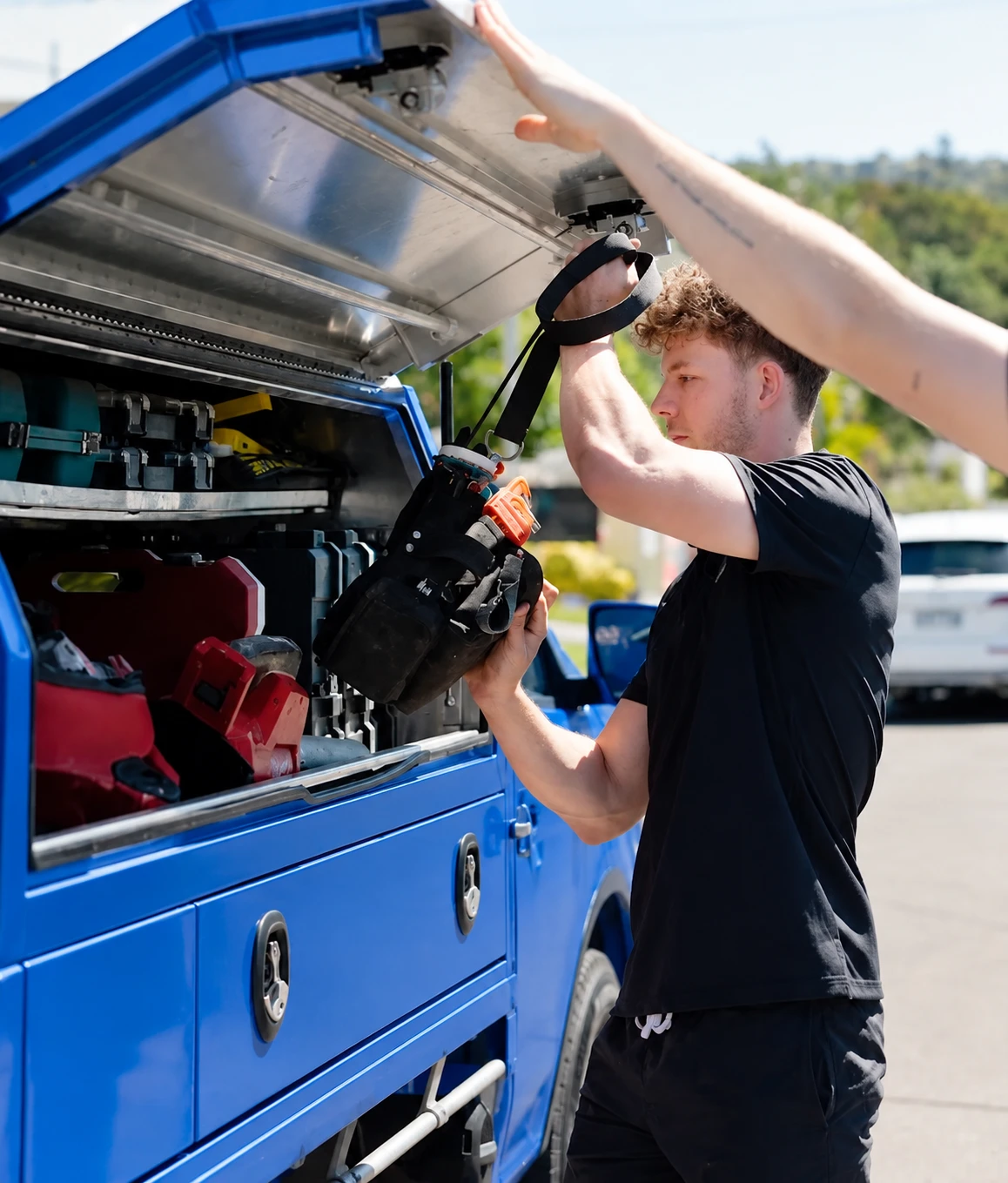Plumber loading equipment from a service van